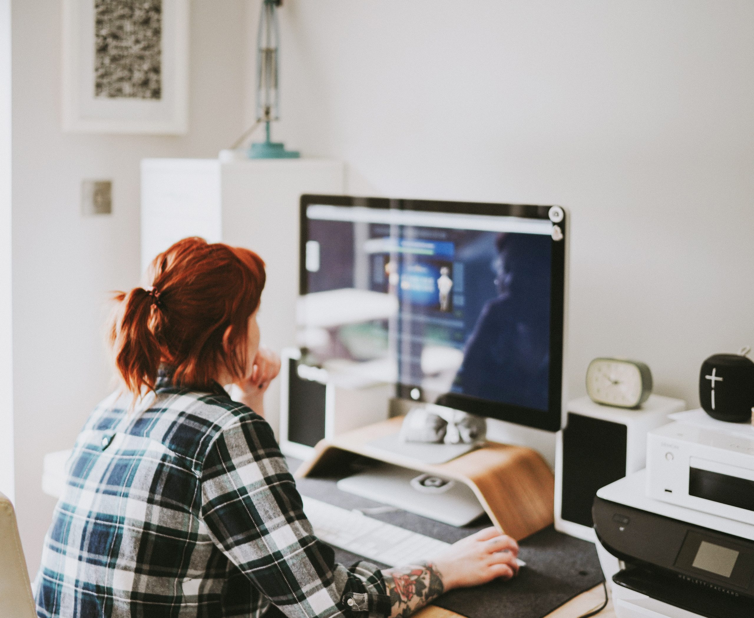 A photo of a woman sitting at a computer in a home office environment
